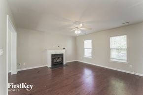 Charlotte house for rent - A spacious living room with a fireplace and a ceiling fan.