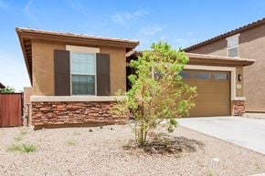 Tucson house for rent - a house with a gravel driveway and a tree in front of it