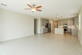 Tucson house for rent - an empty living room and kitchen with a ceiling fan