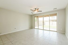 Tucson house for rent - an empty living room with a ceiling fan and a sliding glass door