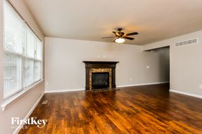 St Peters house for rent - a living room with a fireplace and wooden floors and a ceiling fan