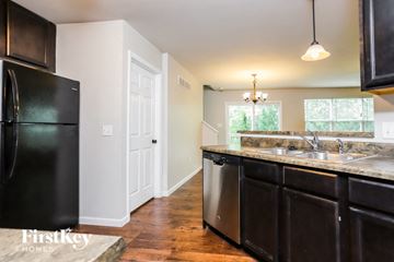 St Peters house for rent - a kitchen with black cabinets and a sink and a refrigerator