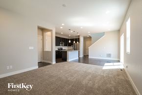 Denver house for rent - an empty living room with a kitchen in the background