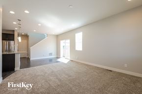 Denver house for rent - an empty living room with a kitchen in the background