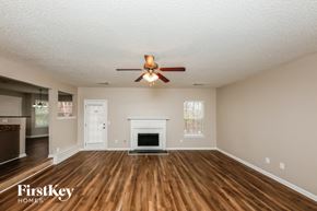 Dallas house for rent - A spacious living room with a fireplace and a ceiling fan.