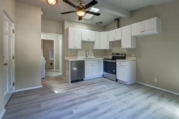 Issaquah apartment for rent - an empty kitchen with white cabinets and a ceiling fan