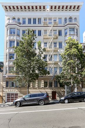 San Francisco apartment for rent - a tall white building with cars parked in front of it