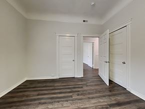 San Francisco apartment for rent - a bedroom with white doors and a hallway with wood flooring