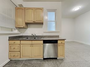 San Francisco apartment for rent - an empty kitchen with wooden cabinets and a stainless steel dishwasher