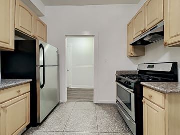 San Francisco apartment for rent - a kitchen with wood cabinets and stainless steel appliances and a refrigerator