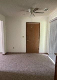 Clinton apartment for rent - an empty living room with a ceiling fan and a door