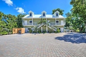 Key Largo apartment for rent - A large white house with a blue roof and a brick driveway.