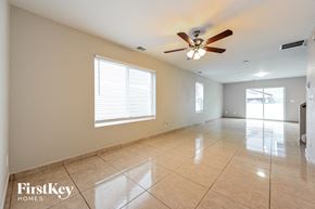 Denver house for rent - an empty living room with a ceiling fan and tiled floors