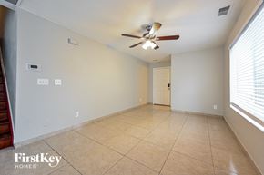 Denver house for rent - an empty living room with a ceiling fan and a tiled floor