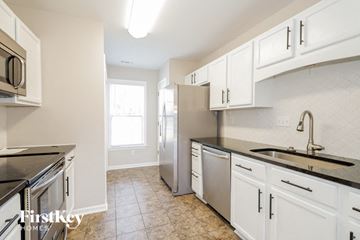 Mount Holly house for rent - a kitchen with white cabinets and stainless steel appliances