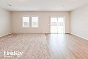 Brookshire house for rent - A spacious room with light wood flooring and two windows.