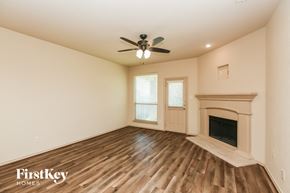 Weatherford house for rent - a living room with a fireplace and a ceiling fan
