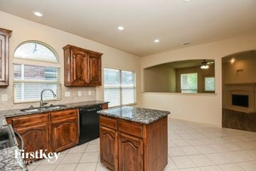 Weatherford house for rent - a kitchen with wooden cabinets and granite counter tops
