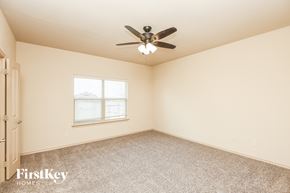 Weatherford house for rent - a bedroom with a ceiling fan and a window