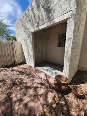 Tucson house for rent - the back yard of a white house with a courtyard and a door
