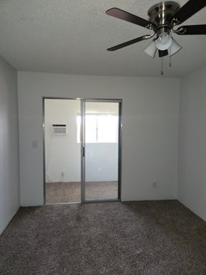 Tucson house for rent - an empty room with a ceiling fan and a sliding glass door