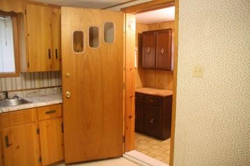 Westville apartment for rent - a kitchen with wooden cabinets and a sink and an open door