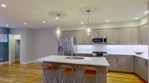 Denver house for rent - a kitchen with a large island with three stools