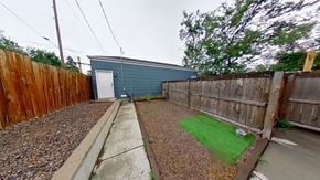 Denver house for rent - a backyard with a wooden fence and a blue building