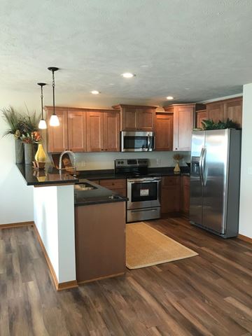 Lincoln house for rent - A kitchen with wooden cabinets and a black countertop.