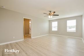 Port Orange house for rent - A spacious room with a ceiling fan and wooden flooring.