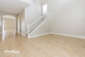 Brandon house for rent - A spacious room with a staircase and a large window.