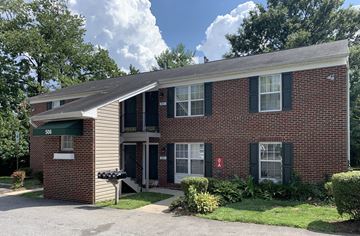 Laurel apartment for rent - a red brick house with green shutters and a driveway