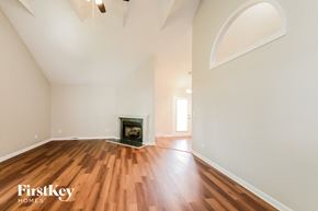 Kernersville house for rent - a living room with white walls and a fireplace and wooden floors