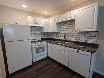 Great Falls apartment for rent - a kitchen with white cabinets and a stove and refrigerator