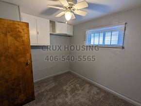 Great Falls house for rent - A room with a ceiling fan and a door leading to another room.
