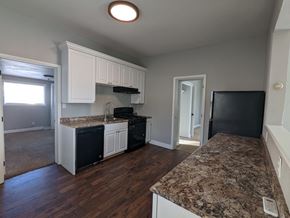 Great Falls house for rent - a kitchen with granite counter tops and black appliances and white cabinets