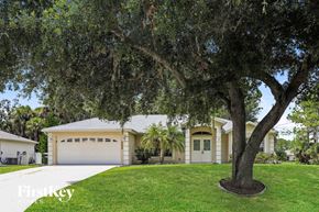 North Port house for rent - a house with a garage and a tree in the yard