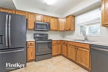 North Port house for rent - a kitchen with wooden cabinets and stainless steel appliances