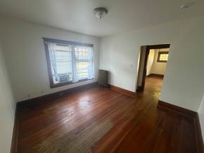 Fremont apartment for rent - A room with wooden floors and a window with a view of a building outside.