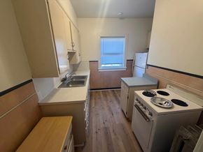 Fremont apartment for rent - A small kitchen with a stove, sink, and window.