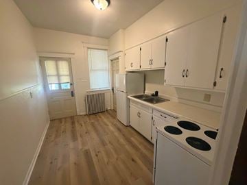 Fremont apartment for rent - A kitchen with white cabinets and a stove top oven.