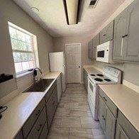 Deridder house for rent - a kitchen with white appliances and white cabinets