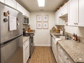 Riverside apartment for rent - A kitchen with a refrigerator on the left and a sink on the right.