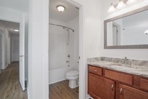 Foley house for rent - A bathroom with a white toilet and a wooden vanity.