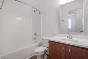 Foley house for rent - A white bathroom with a toilet, sink, and bathtub.