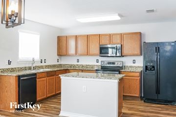 Cedar Hill house for rent - A kitchen with wooden cabinets and a black refrigerator.
