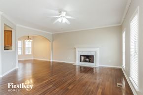 Chelsea house for rent - A spacious room with a fireplace and wooden floors.