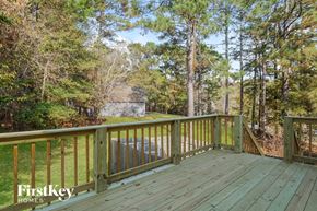 Chelsea house for rent - A wooden deck with a railing and trees in the background.