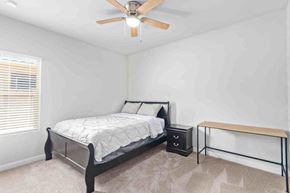Tucson house for rent - a bedroom with a bed and a ceiling fan