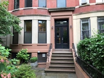 Brooklyn apartment for rent - A red brick building with a black door and windows.